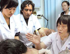 Dr Jose Luis Coba Carrion (2nd from left) of Ecuador observes Dr Bai Yulan (front) giving a patient acupuncture. [Jiang Dong/ China Daily] 