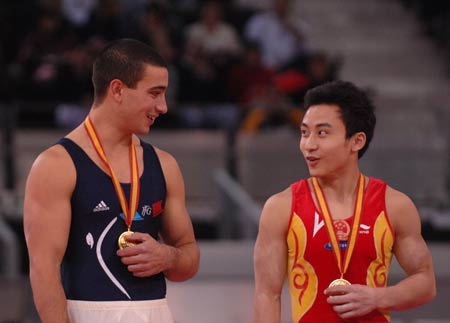 France's Yann Cucherat (L) talks with China's Feng Zhe on the awarding podium after competing during the men's parallel bars final at the 14th Artistic Gymnastics World Cup in Madrid, capital of Spain, on Dec. 14, 2008. Cucherat and Feng claimed the title of the event with the same result of 16.225 points. 