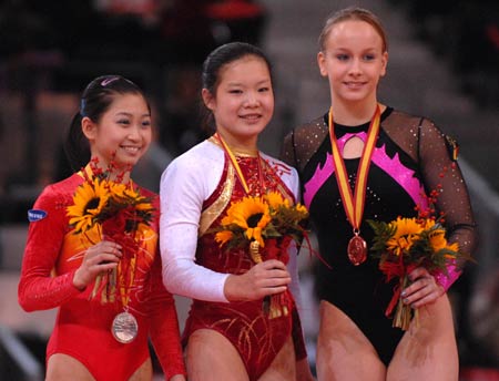 China's Chen Fei (C), Jiang Yuyuan (L) and Romania's Sandra Raluca Izbasa pose for a photo on the awarding podium after competing during the women's floor final at the 14th Artistic Gymnastics World Cup in Madrid, capital of Spain, on Dec. 14, 2008. Chen claimed the title of the event with a result of 15.375 points. 