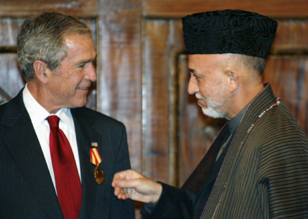 U.S. President George W. Bush receives a medal from Afghan President Hamid Karzai during their meeting at the Presidential Palace in Afghanistan December 15, 2008.