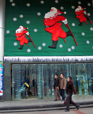 A Santa Claus decoration is seen on the gate of a shopping mall in Guiyang, capital of southwest China's Guizhou Province, Dec. 16, 2008. 