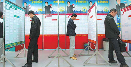 Job-seekers look for suitable vacancies at a job fair in Dongguan.[China Daily]