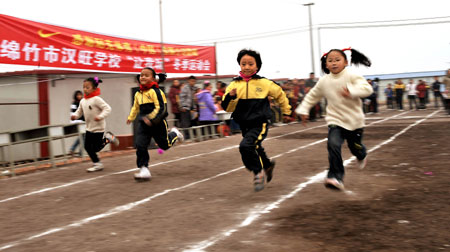 Students of Hanwang School run at a school sports meeting in Mianzhu, Sichuan Province on Tuesday. A group of volunteers attended a program aimed at boosting health awareness among local students caught in the deadly May 12 earthquake. 