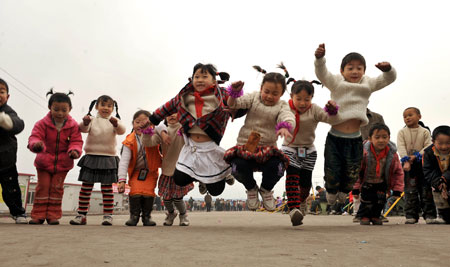 Students of Qingping Primary School jump while playing a game in Mianyzhu, Sichuan Province on Tuesday. A group of volunteers attended a program aimed at boosting health awareness among local students caught in the deadly May 12 earthquake. 