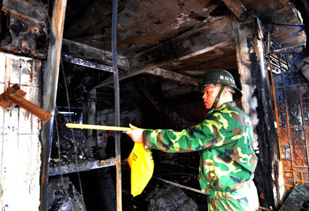 A firefighter inspects the scene where a cloth store was burned down in a fire in the Hanjiang District of Putian City, south China's Fujian Province, on Dec. 17, 2008. 