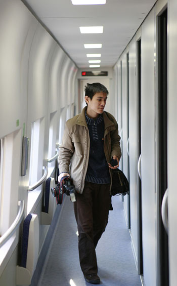 A reporter walks along the gangway inside a couchette of a new CRH sleeper train that debuts in Shanghai on Tuesday, December 16, 2008.