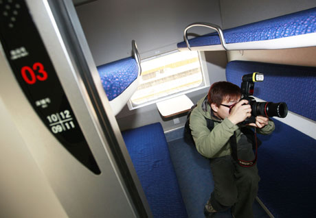 A journalist takes photos of a sleeper aboard a new CRH train in Shanghai on Tuesday, December 16, 2008. 