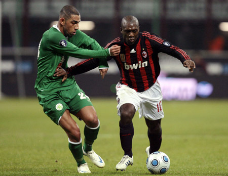 AC Milan's Clarence Seedorf (R) fights for the ball with Wolfsburg's Ashkan Dejagah during their UEFA Cup soccer match at the San siro stadium in Milan December 17, 2008.