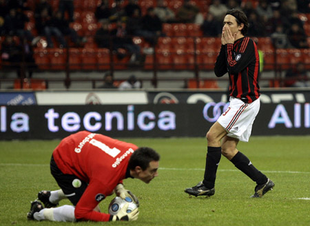 AC Milan's Filippo Inzaghi (R) reacts after missing a scoring opportunity as Wolfsburg's goalkeeper Diego Benaglio holds the ball during their UEFA Cup soccer match at the San siro stadium in Milan December 17, 2008.