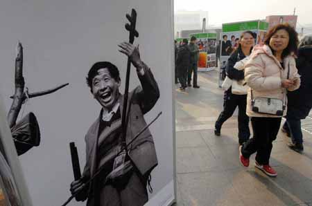 People walk past an old photo at an exhibition featuring China's 30 years' reform and opening-up at Wangfujing Street in Beijing, China, on Dec. 16, 2008. 