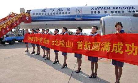 Airport staff members welcome passengers to board the plane for Taipei of China's Taiwan Province, in Fuzhou, capital of southeast China's Fujian Province, Dec. 18, 2008. An airplane carrying 196 passengers took off on Thursday from Fuzhou for Taipei, marking the start of direct air passenger transport between the two citites. 