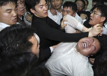 Members (R) of the opposition from the Democratic Party and the Democratic Labour Party scuffle with security guards as they attempt to enter a parliamentary committee room, where the ruling Grand National Party plans to introduce a bill regarding the U.S.-South Korea FTA talks, at the National Assembly in Seoul December 18, 2008. 