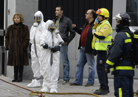 Emergency workers stand inside the door at the U.S. embassy in Madrid after it received a suspicious envelope December 17, 2008.