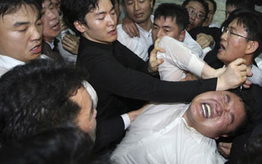 Members (R) of the opposition from the Democratic Party and the Democratic Labour Party scuffle with security guards as they attempt to enter a parliamentary committee room, where the ruling Grand National Party plans to introduce a bill regarding the U.S.-South Korea FTA talks, at the National Assembly in Seoul December 18, 2008.