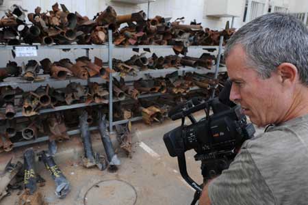 A cameraman films the remains of rockets that landed in Sderot at the police station in Sderot, southern Israel, Dec. 18, 2008. 