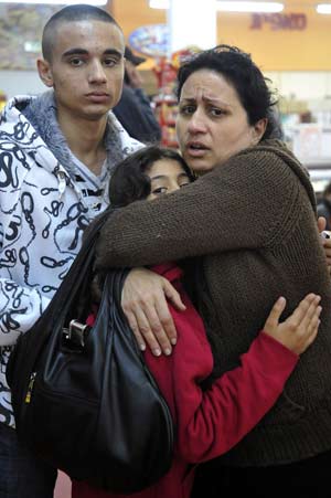 Israelis react after a rocket fired by Palestinian militants in Gaza landed in the southern town of Sderot Dec. 17, 2008. Palestinian militants in the Hamas-ruled Gaza Strip stepped up rocket attacks on southern Israel on Wednesday, wounding at least two people and raising tensions two days before a ceasefire was set to expire.