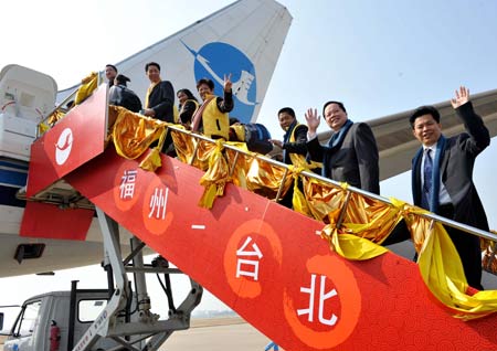 Passengers wave while getting on board leaving for Taipei, in Fuzhou, capital of southeast China's Fujian Province, Dec. 18, 2008. 