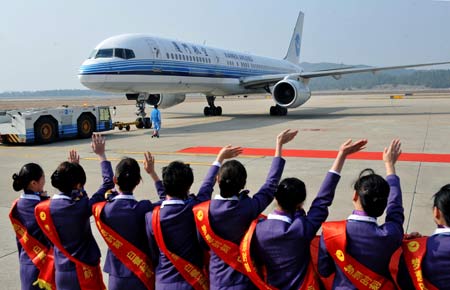 Airport staff members welcome passengers to board the plane for Taipei of China's Taiwan Province, in Fuzhou, capital of southeast China's Fujian Province, Dec. 18, 2008. An airplane carrying 196 passengers took off on Thursday from Fuzhou for Taipei, marking the start of direct air passenger transport between the two citites. 