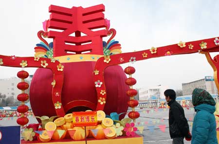 Local residents view the giant red lantern at the spring lantern fair held in Bole City, northwest China&apos;s Xinjiang Uygur Autonomous Region, Dec. 18, 2008. With the coming of New Year and the Chinese traditional Spring Festival, Chinese people started to prepare traditional decorations.