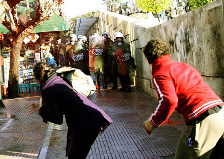 Young protestors throw red dye at riot police during a demonstration in Athens, capital of Greece, Dec. 18, 2008. 