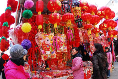 Local residents select home decorations for the upcoming New Year in Yantai city, east China's Shandong Province, Dec. 18, 2008. With the coming of New Year and the Chinese traditional Spring Festival, Chinese people started to prepare traditional decorations. [Xinhua]