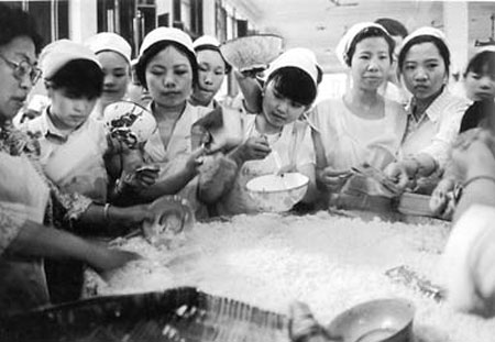 1989, textile workers feed themselves from a communal, bamboo-made rice bowl at a factory in Sichuan. Under the planned economy, jobs at State-owned enterprises and collectives were known as 'iron rice bowls' as they provided employees with all they needed to live, including their food. Today, privately owned factories provide job opportunities for much of the population. 