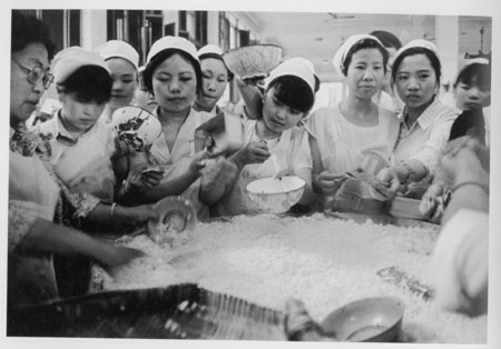 1989, textile workers feed themselves from a communal, bamboo-made rice bowl at a factory in Sichuan. Under the planned economy, jobs at State-owned enterprises and collectives were known as 'iron rice bowls' as they provided employees with all they needed to live, including their food. Today, privately owned factories provide job opportunities for much of the population. [China Daily]
