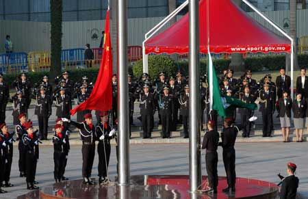 The government of Macao Special Administrative Region (SAR) holds a flag-raising ceremony of China's national flag (L) and the Macao SAR flag to mark the ninth anniversary of Macao's return to the motherland at the Golden Lotus Square in Macao, south China, Dec. 20, 2008. [Xinhua] 