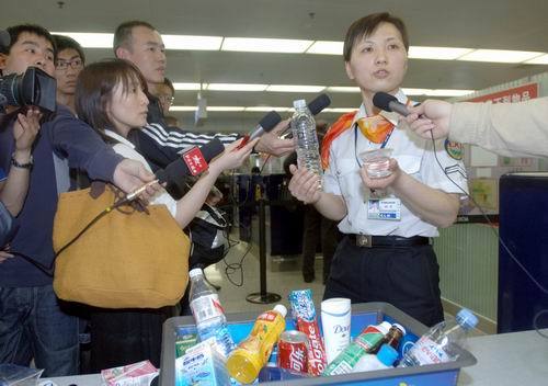 In this file photo a security worker in the Beijing Capital International Airport explains related flight safety regulations to reporters.