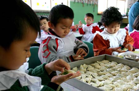 Children make dumplings to celebrate the upcoming winter solstice day at a kindergarten in Hami, northwest China's Xinjiang Uygur Autonomous Region, Dec. 19, 2008. As the Chinese tradition, people eat dumplings to celebrate the winter solstice day. [Cai Zengle/Xinhua] 