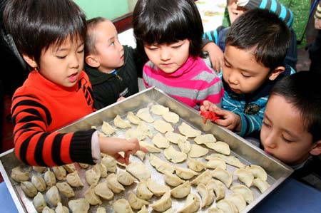 Children count the dumplings they made to celebrate the upcoming winter solstice at a kindergarten in Hami, northwest China's Xinjiang Uygur Autonomous Region, Dec. 19, 2008. As the Chinese tradition, people eat dumplings to celebrate the winter solstice day. [Cai Zengle/Xinhua] 