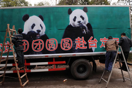 Workers decorate the truck that will carry Tuan Tuan and Yuan Yuan, the two pandas donated and to be sent by the Chinese mainland to Taiwan, at a panda breeding base in Ya'an county, southwest China's Sichuan province, December 21, 2008. [Xinhua]