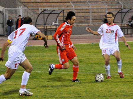 Qu Bo (C), player of Chinese men's soccer national team, contends with Jordan's players in a friendly on Sunday. China beat the hosts 1-0 in a friendly held in Jordan's capital of Amman, the last stop of the team's West Asian training tour. 