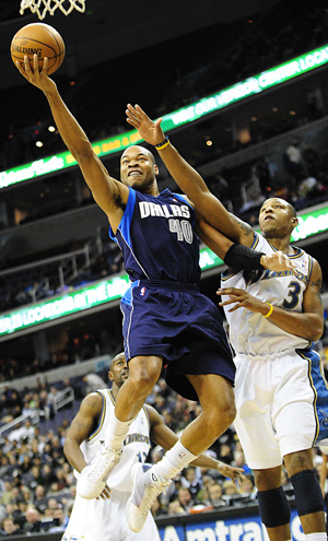 Devean George of Dallas Mavericks (L) goes for a score as Caron Butler of the Washington Wizards tries to defense him during the NBA basketball game in Washington, the United States, December 21, 2008. Mavericks won 97-86. 