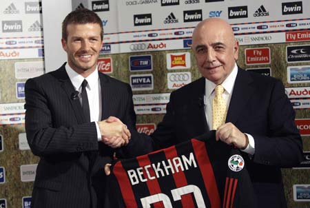 English soccer player David Beckham (L) shakes hands with AC Milan's vice president Adriano Galliani during his presentation in San Siro stadium in Milan December 20, 2008. The Los Angeles Galaxy player joins AC Milan on loan in January.