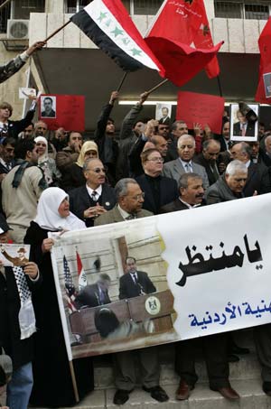 Protesters hold a poster showing U.S. President George W. Bush dodging a shoe, during a protest in Amman December 20, 2008. 