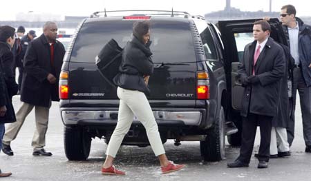 U.S. President-elect Barack Obama's wife Michelle (C) gets ready to board a plane for a 12 day Hawaii vacation in Chicago December 20, 2008.