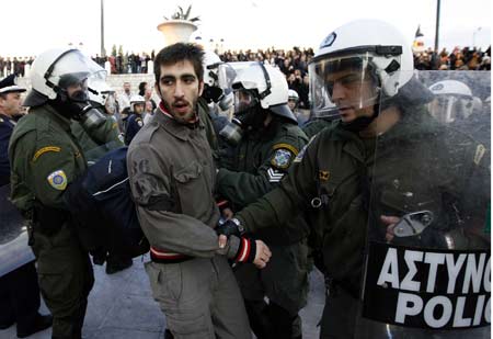 A protester is detained by policemen during a demonstration in Athens Dec. 20, 2008. People protesting over the fatal shooting of a youth in central Athens two weeks ago, threw garbage at the Christmas tree at central Syntagma square. 