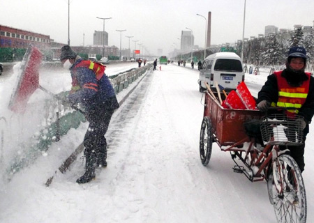 Workers clear snow on a street in Tianjin, north China, Dec. 21, 2008. 