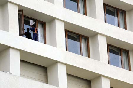 A worker cleans windows of the Trident hotel of the Oberoi Group in Bombay, India, Dec. 21, 2008. 