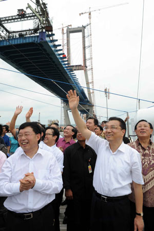 Visiting Chinese Vice Premier Li Keqiang (front R) waves hands as he visits the construction site of the Suramadu ( Surabaya-Madura) bridge, which will be the longest of its kind, in Indonesia, Dec. 21, 2008.