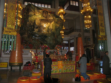 People pay their respects to the Jade Buddha at the Jade Shakyamuni Buddha Park of Anshan city, northeast China&apos;s Liaoning province on December 19, 2008. The Jade Shakyamuni Buddha statue carved out of a 260-ton jade stone is being displayed here for worshippers from all over the world. The statue was accredited as the biggest of its kind in the world by the Guinness World Records in December 2002. [Chinadaily.com.cn]