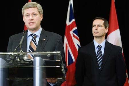 Canada's Prime Minister Stephen Harper speaks to the media as Ontario Premier Dalton McGuinty (R) watches on in Toronto, December 20, 2008. The Canadian and Ontario governments announced on Saturday they would follow the United States in providing C$4 billion (US$3.3 billion) in emergency loans to the Canadian arms of Detroit's ailing automakers to keep them operating while they restructure their businesses.[Xinhua]