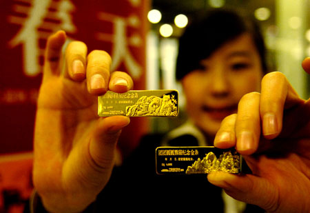 An employee shows two commemorative gold bars of Tuan Tuan and Yuan Yuan leaving for Taiwan in Beijing, capital of China, Dec. 22, 2008. The gold bars for commemoration of Tuan Tuan and Yuan Yuan leaving for Taiwan, manufactured under the supervision of the National Museum of China, were issued Monday. The 4-year-old giant pandas, Tuan Tuan and Yuan Yuan, offered by the Chinese mainland are going to leave for Taiwan Tuesday. [Xinhua]