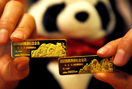 An employee shows two commemorative gold bars of Tuan Tuan and Yuan Yuan leaving for Taiwan in Beijing, capital of China, Dec. 22, 2008. [Xinhua] 