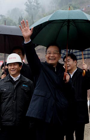 Chinese Premier Wen Jiabao waves to the construction workers during his visit to a water dam construction site in southwest China's Chongqing Municipality Dec. 21, 2008. During his trip, Wen visited a number of local factories, communities, villages and worksites. 