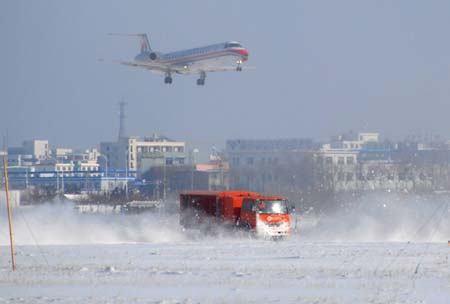 snow removal truck cleans up snow on the runway of the Laishan International Airport in Yantai, east China's Shandong Province, Dec. 22, 2008. Residents from all circles here went to clean the snow on roads and streets in the city, as it snowed heavily on Sunday. 