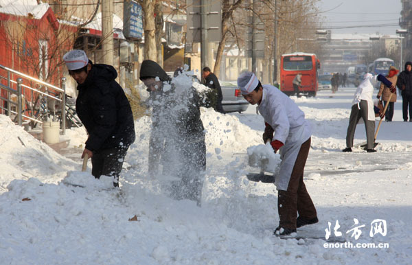  Residents sweep snow in Tianjin, north China's coastal municipal city, on December21, 2008.