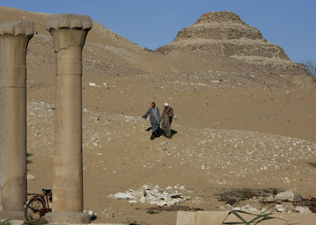 Men walk near the site of two recently discovered tombs in Saqqara December 22, 2008. Egyptian archaeologists have found the tombs of two court officials, in charge of music and pyramid building, in a 4,000 year old cemetery from the reign of Pharaoh Unas. The tombs were found buried in the sands south of Cairo and could shed light on the fifth and the sixth dynasties of the Old Kingdom, said Egypt's antiquities chief Zahi Hawass.