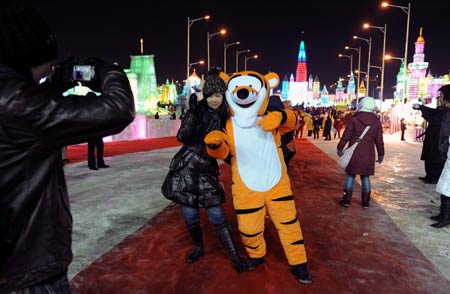 A visitor poses for photos in the Ice and Snow World in Harbin, capital of northeast China's Heilongjiang Province, on Dec. 23, 2008. The annual ice and snow world in Harbin began a test run on Tuesday. [Xinhua]